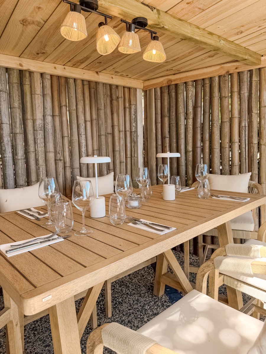 Salle en bambou avec table dressée et luminaires