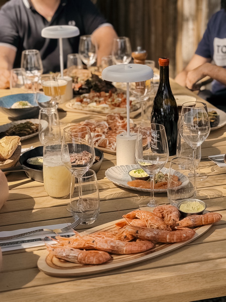 Table garnie de crevettes, verres de vin et partage